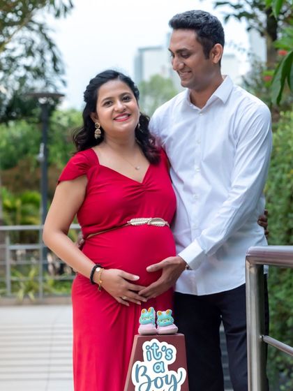 A happy couple celebrating their baby boy on the way. This outdoor shot includes a cute "It's a Boy" prop, making it a perfect announcement photo.