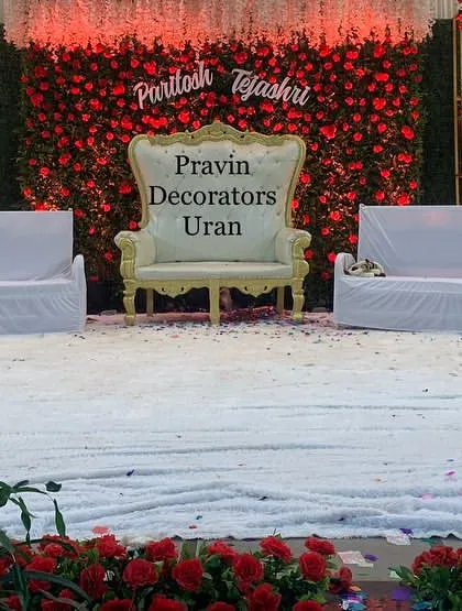An in-progress shot of a wedding stage setup. This shows the base of our red rose floral wall and the elegant seating before the final lighting and finishing touches are applied.