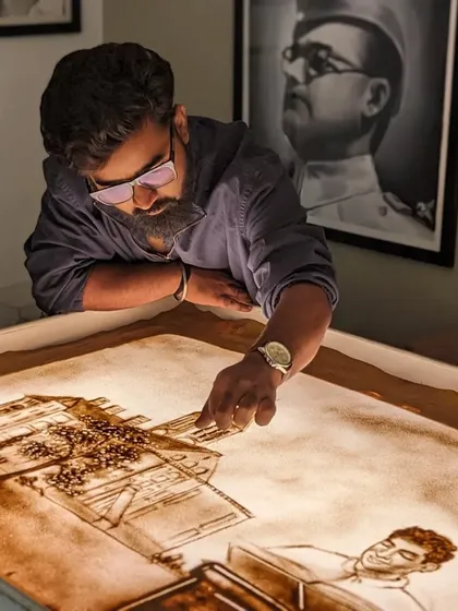 Working on a scene from Ratan Tata's life, capturing his journey through my sand art.