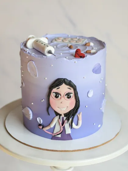 A personalized cake for a doctor. The design features a cute, hand-drawn caricature of the doctor, a stethoscope, and other medical-themed fondant details on a purple ombre cake.
