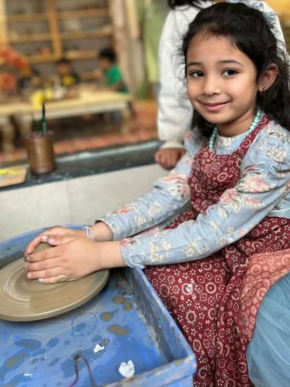 With a smile, she puts her hands to the clay, ready to begin. I make sure every child feels comfortable and excited to try new things like our pottery wheel.