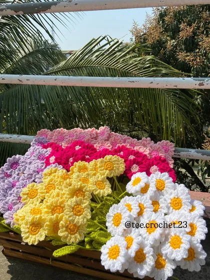 A crate filled with beautiful, multi-colored daisy stems.