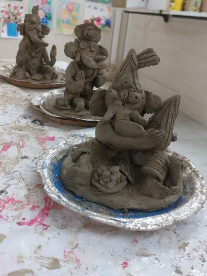 A close-up of the finished clay Ganesha idols, each with its own personality. You can see the little details, from the modaks to the expressions, that the kids added themselves.