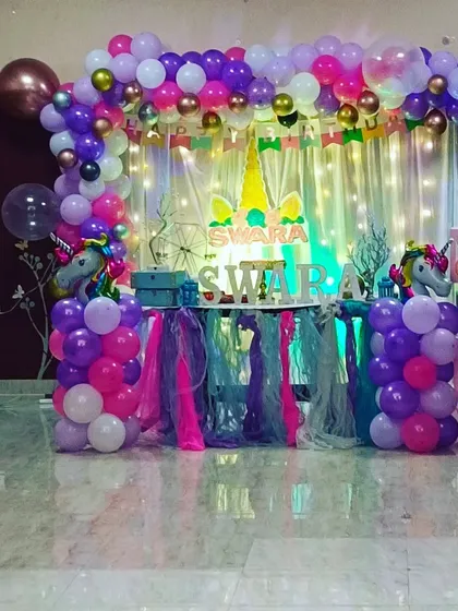 A wide shot of a unicorn-themed birthday setup, showcasing the balloon arch, decorated table, and themed props. We transform any room into a magical party space.