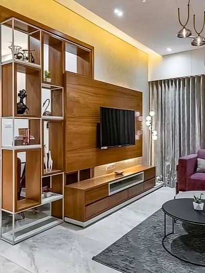 In open-plan apartments, defining different zones is key. We used a stylish, open-shelf partition to visually separate the living and dining areas, adding architectural interest and display space without blocking light or making the area feel closed off.
