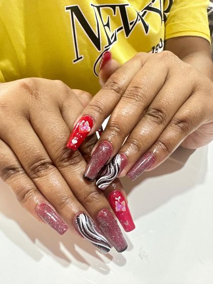 This creative set combines multiple designs, including pink glitter, black and white marble swirls, and red nails with encapsulated butterfly details.