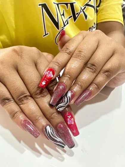 This creative set combines multiple designs, including pink glitter, black and white marble swirls, and red nails with encapsulated butterfly details.