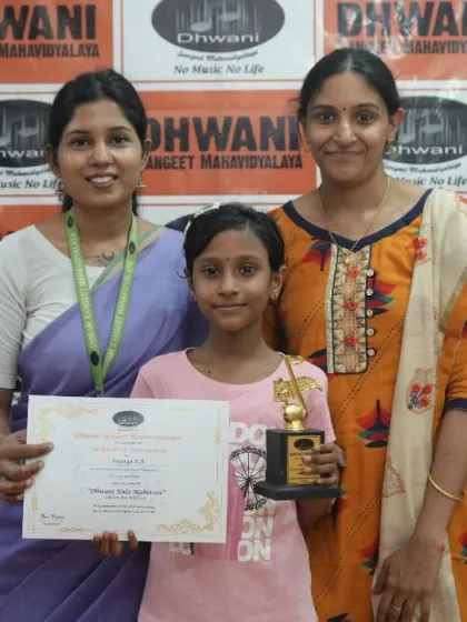 A teacher and student with her mother, celebrating her success.