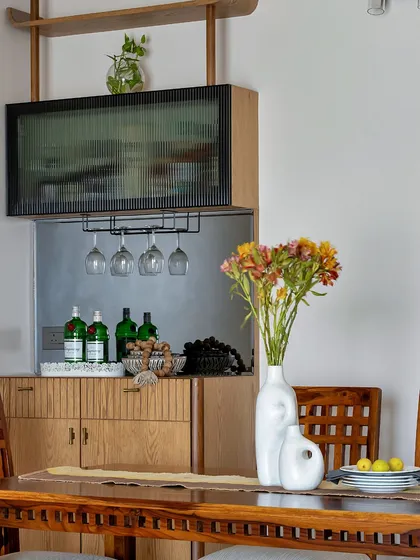 A close-up of a wooden bar cabinet with a fluted glass door and integrated wine glass storage. This piece is perfect for adding a sophisticated touch to a dining or living area.
