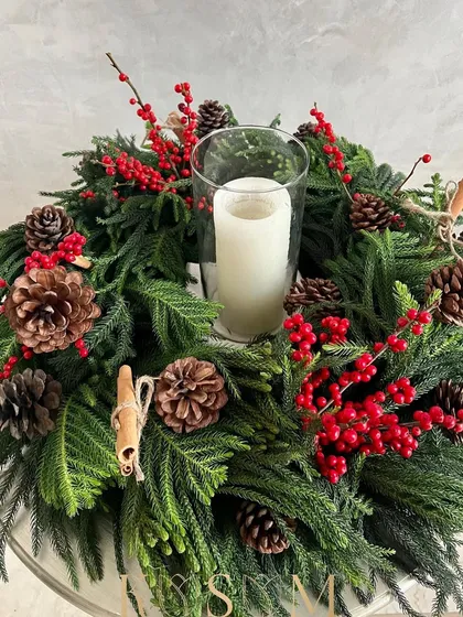 Another angle of this versatile Christmas wreath. The combination of natural elements like pinecones and cinnamon with festive red berries makes it a timeless piece for your holiday decor.