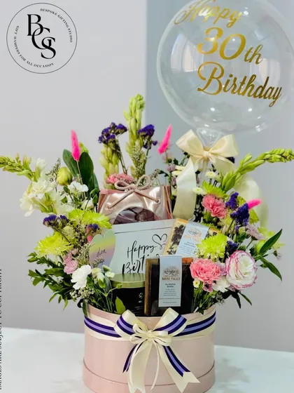 A spectacular 30th birthday hamper designed to wow. This large pink hatbox is overflowing with fresh flowers, curated gifts, and a personalized balloon, making it the ultimate celebratory statement piece.