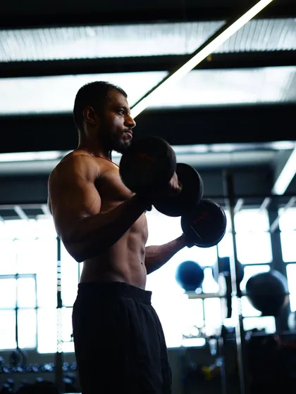 The silhouette of hard work. A focused bicep curl session, building defined arms and upper body strength.