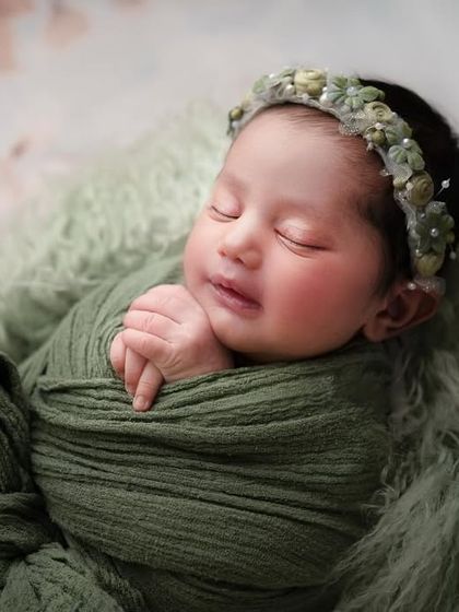 The most adorable newborns in the classiest of setups. A simple green swaddle and a soft, furry base are all that's needed to create a stunning, baby-focused portrait.