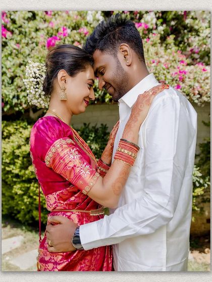 An intimate portrait of the couple in their wedding attire, sharing a tender moment against a floral background.