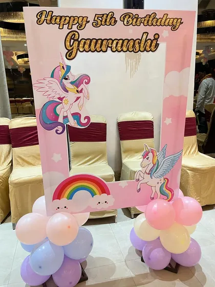 A creative unicorn-themed photo booth frame. This custom cutout allows guests to take fun pictures within the magical unicorn and rainbow design.