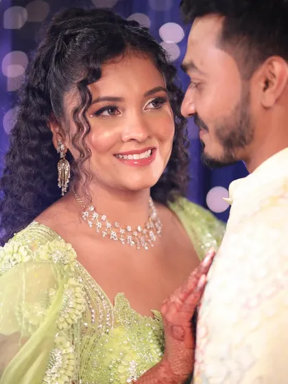 A beautiful Carnival look for a curly-haired bride. We embraced her natural texture with a half-up hairstyle and created a fresh, glowing makeup look to match her vibrant lime green lehenga.
