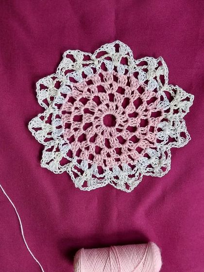 A 5-inch doily made with variegated pink and white thread.