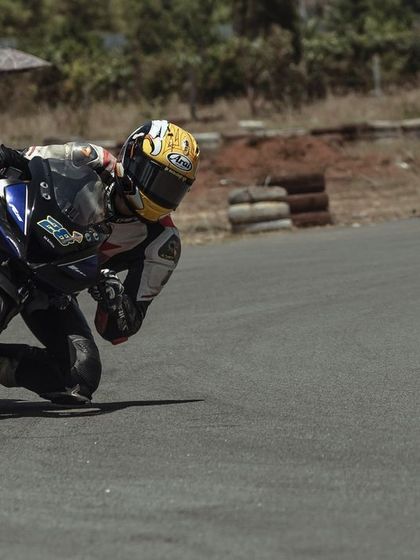 A rider on a Yamaha R15 leans into a turn, demonstrating the focus and precision we teach at our racing school. Mastering corners is key to improving your lap times.
