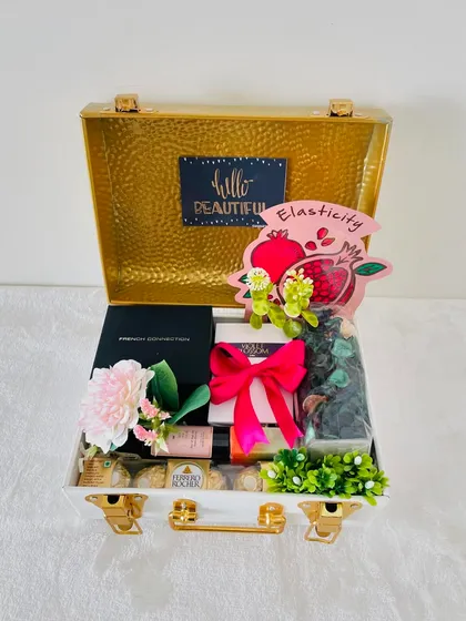 This white and gold metal trunk is perfect for her. I've curated it with Ferrero Rocher, skincare items, and potpourri, making it a luxurious gift for Rakhi or a birthday.