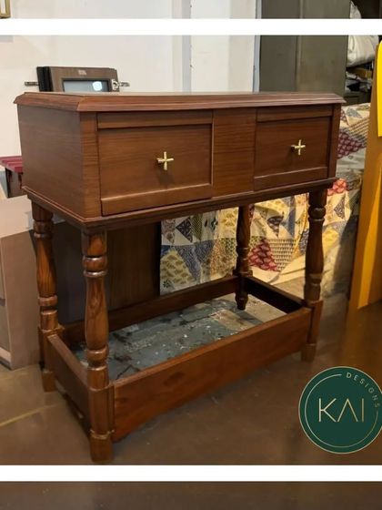 A classic wooden console or small cabinet with turned legs and simple brass hardware. This piece showcases traditional woodworking skills and offers a timeless storage solution.