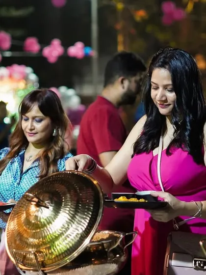 Guests enjoying the buffet at an outdoor birthday party. We love seeing people delight in the food we've prepared, creating a warm and happy atmosphere for any celebration.