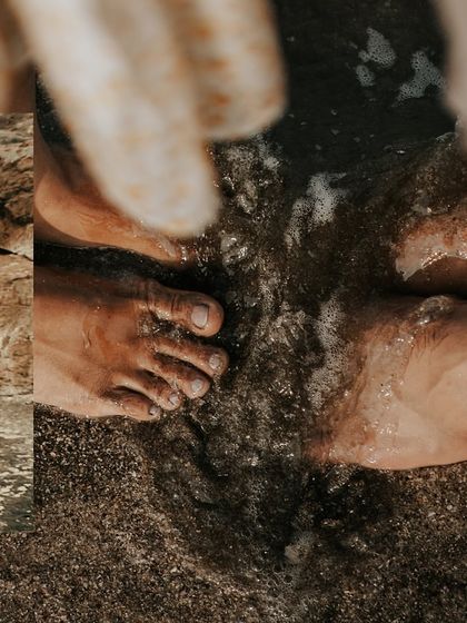 A detailed shot focusing on the couple's feet in the water, grounding their epic waterfall pre-wedding shoot in a simple, sensory moment.