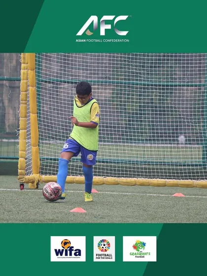 A young player practicing his dribbling skills during the AFC Grassroots Day event.