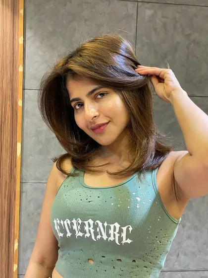 A front-facing view of this chic, medium-length balayage. The face-framing highlights are perfectly placed to enhance her features.