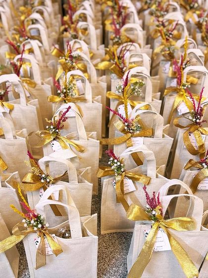 Capturing tradition in every Thamboola moment. These jute bags, adorned with golden ribbons and dried flowers, are a beautiful and elegant return favor for any celebration.