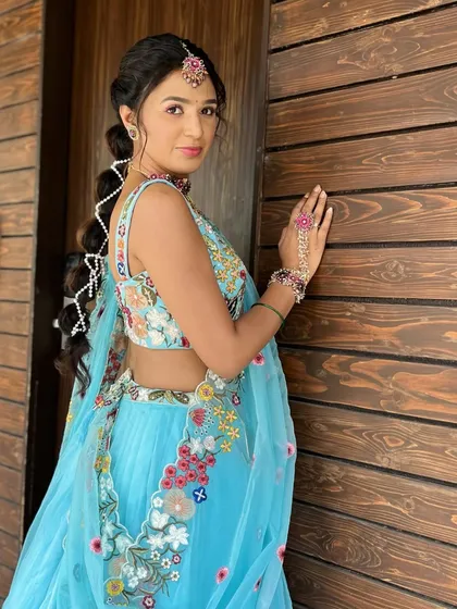 A dreamy look for a Haldi ceremony. The bubble braid gives a playful, Jasmine-like vibe, perfectly complementing her fresh and fun floral lehenga.