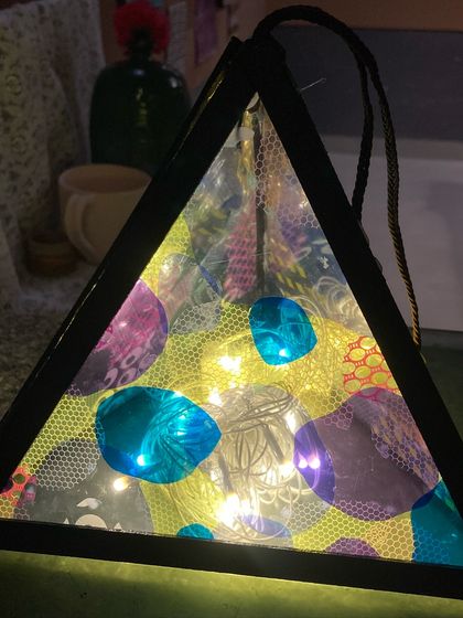 Another beautiful example of a finished Diwali lantern, glowing with light and showcasing intricate patterns.