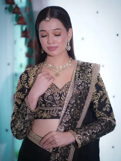 A timeless look featuring a black and gold outfit. The makeup is fresh and radiant, with soft glowing skin and a touch of shimmer.