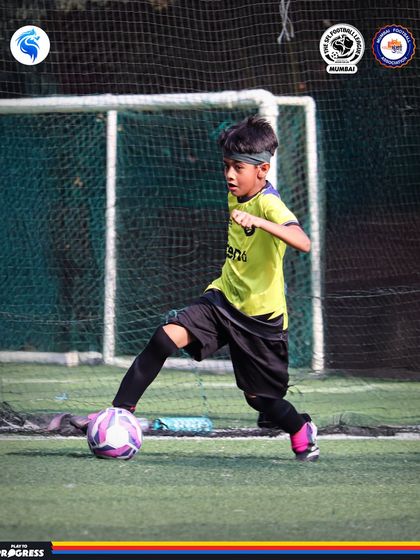 A young player with his eyes on the ball, ready to make his next move. Focus and determination are key.