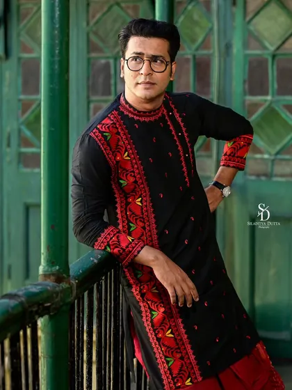A relaxed pose from Anirban, leaning against the balcony railing. This shot captures a more casual and thoughtful side, while still highlighting the intricate embroidery of the kurta.