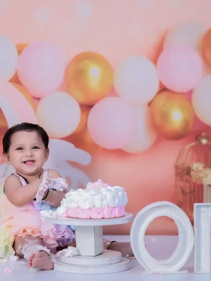 A first birthday is a huge milestone, and what's a party without some cake? My cake smash sessions are all about fun, laughter, and making a glorious mess. This little one is having the time of her life with a pastel rainbow dress and a delicious cake to dig into.