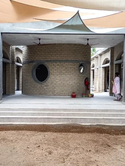 The central courtyard of Sai Kirupa Special School in Tiruppur, designed as a sensory and interactive hub. The cylindrical structure and surrounding arches create a variety of spaces for children to explore.