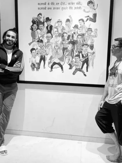 Actors Ranveer Singh and Aamir Khan standing beside the wall poster of my caricatures at the Aamir Khan Productions office.
