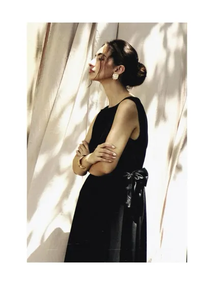 A timeless black dress from the AVEKA 'Love Letter' campaign. The styling, with the elegant updo and the soft light, is inspired by classic Hollywood glamour.