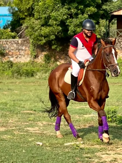 An experienced rider practices in our open field. We offer training that goes beyond the arena, preparing riders for varied terrain.
