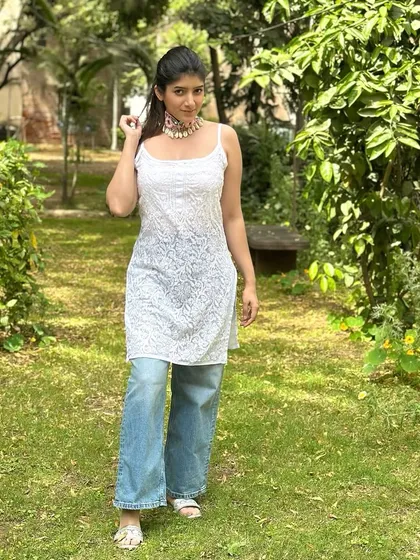 For a chic fusion look, I've paired a sleeveless Lucknowi kurta with wide-leg jeans. The addition of a statement choker elevates this simple combination, making it perfect for a festive brunch.