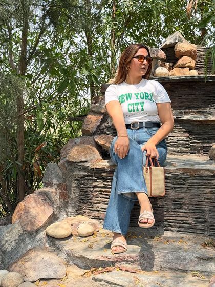 A closer look at the travel outfit. The belt adds a bit of structure to the casual tee and jeans combo, and the tinted sunglasses provide a stylish finishing touch.