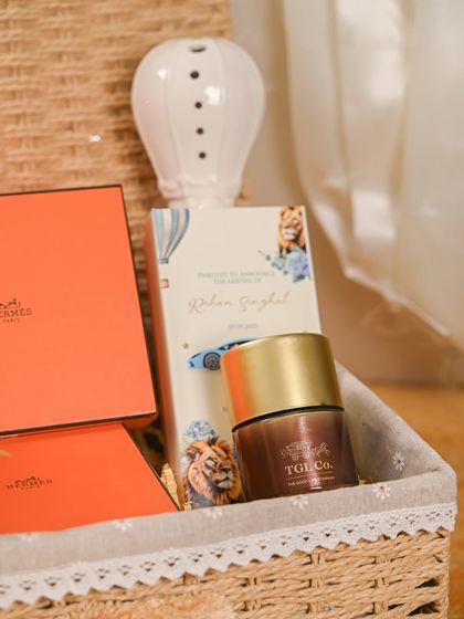 A closer look at the personalized details in this baby announcement hamper. It includes a custom chocolate bar with the baby's name, Rohan Singhal, alongside a hot-air balloon diffuser and other curated items.