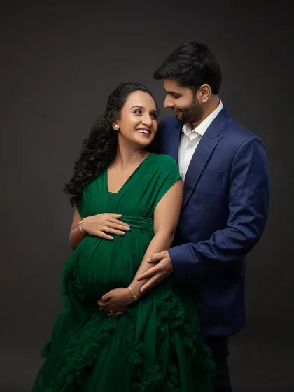 The look they share is full of love and excitement. His classic blue suit perfectly complements her stunning green gown.