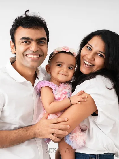 A burst of happy energy from a beautiful family of three. Their coordinated white shirts and big smiles make for a perfect, classic family photo.