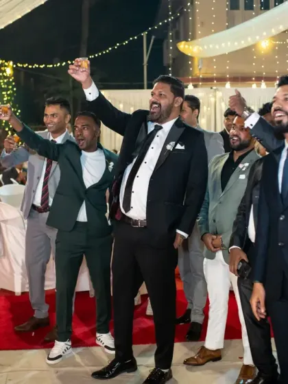 A toast to the happy couple! The groom and his groomsmen raise their glasses in celebration during the wedding reception.