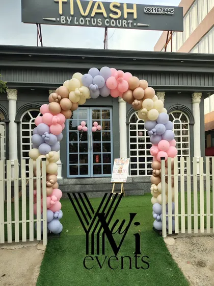 A beautiful pastel balloon arch at the entrance of a venue for a baby shower, creating a welcoming sight for guests.