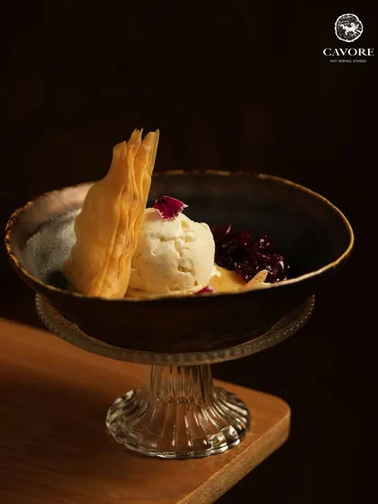 The final act of the meal. A scoop of rich, house made ice cream is paired with a sweet fruit compote and a crisp, flaky tuile for a dessert that is both comforting and elegant.