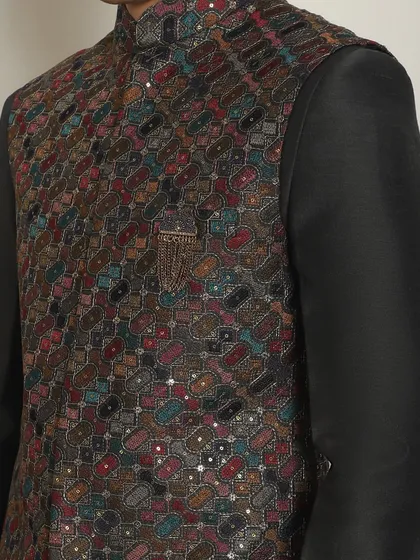 A detailed view of the vibrant, multi-colored embroidery on the charcoal bundi. This piece is both comfortable and glamorous, perfect for a night of celebration.