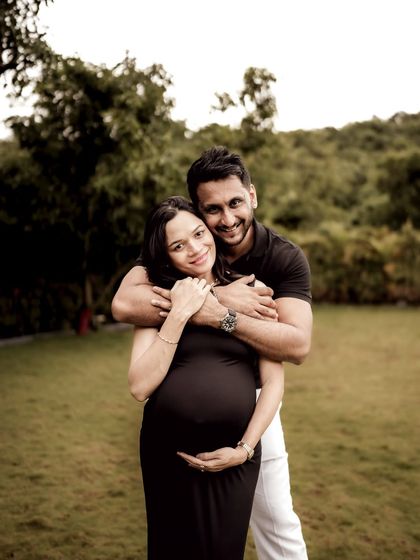 A joyful portrait of the couple, with him embracing her from behind. They are both smiling at the camera, sharing their happiness with the world.