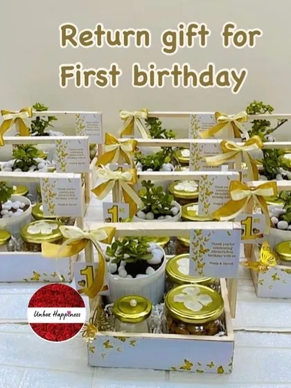 A display of the elegant white and gold butterfly-themed first birthday return gifts, perfect for a sophisticated celebration.